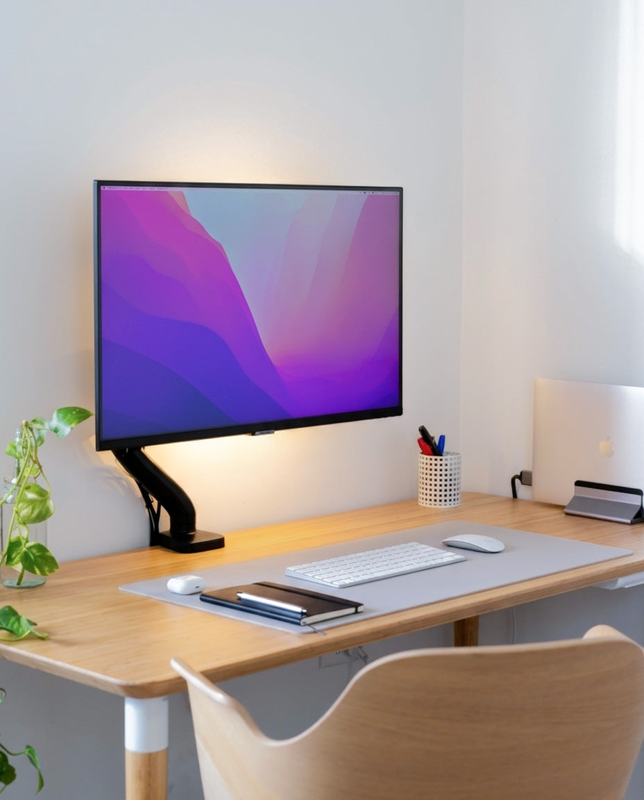 Modern office desk setup with a computer monitor, keyboard, mouse, and chair.